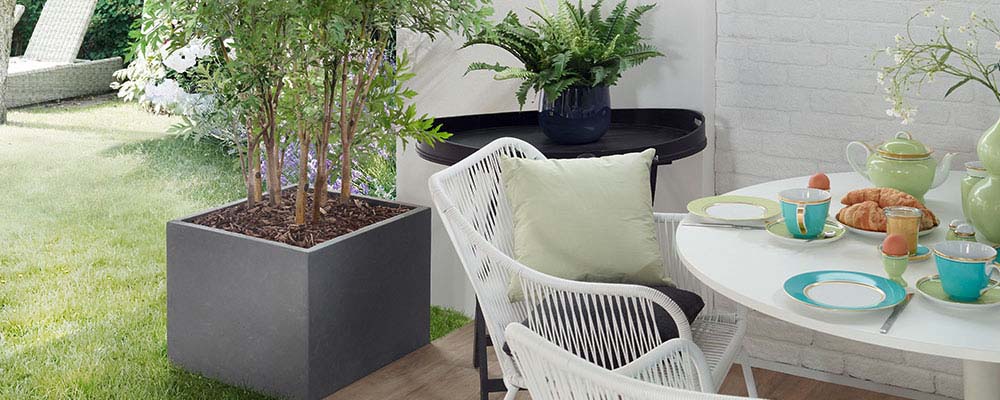 Die Terrasse gestalten mit Pflanzwerk® Blumenkübeln in verschiedenen Farben